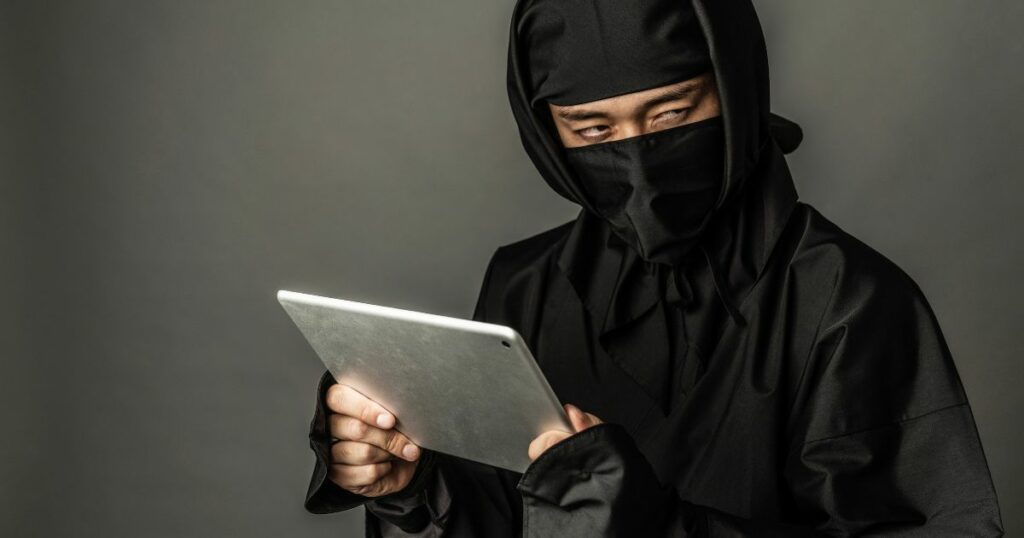 man in ninja costume using tablet
