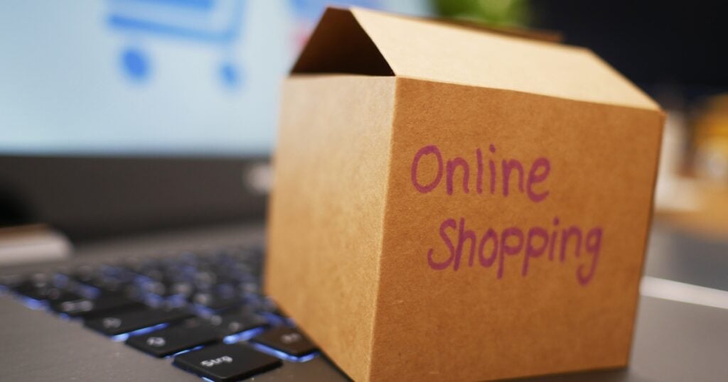 small box with a label - online shopping placed on the laptop