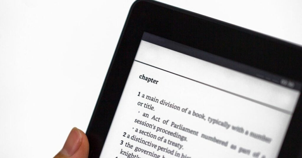 picture focuses on lettering of an open book in tablet screen.