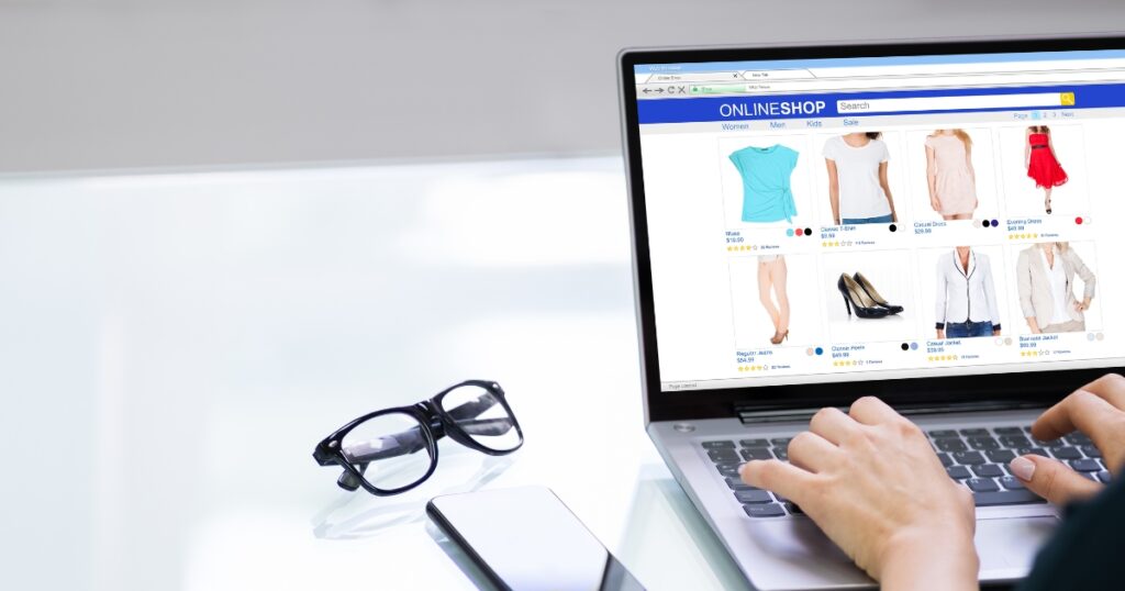 visiting a clothing website in laptop with glasses on the sides